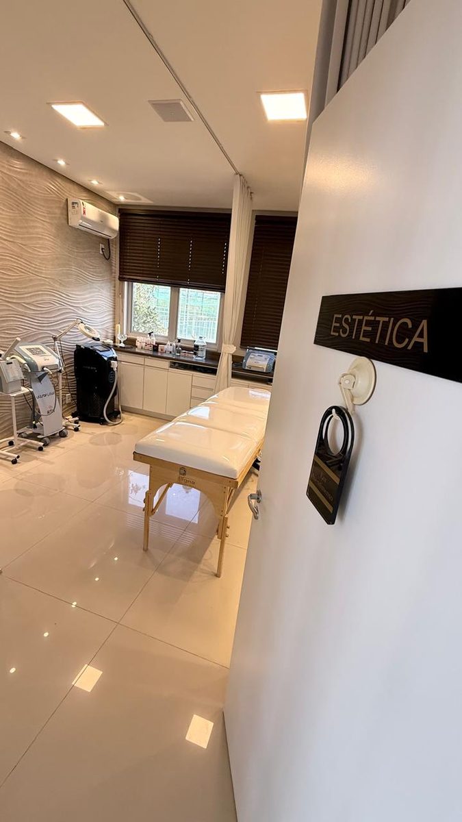 Sala de estética da UNICORPOS, com maca e equipamentos para procedimentos faciais e corporais